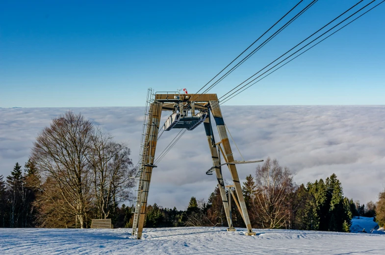 snow covered ski slope with a wooden structure and wire line above