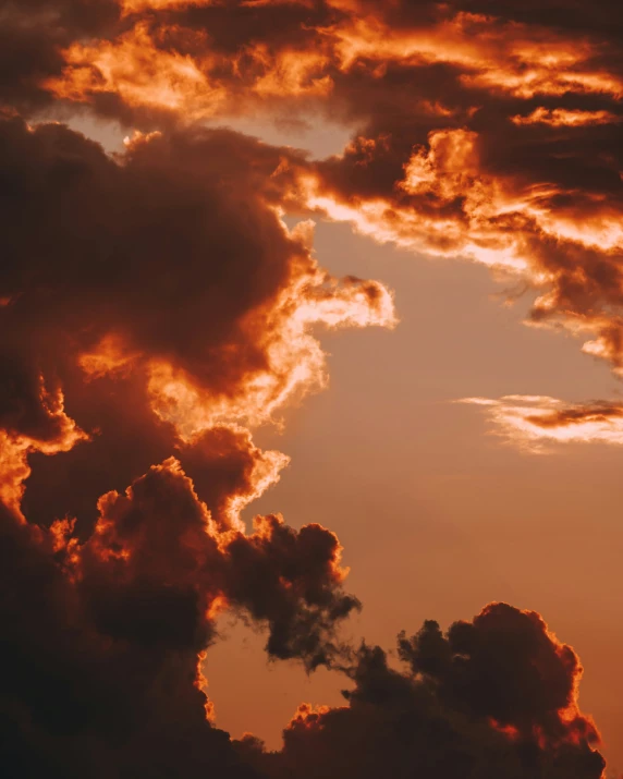 orange and red clouds glow against the sun