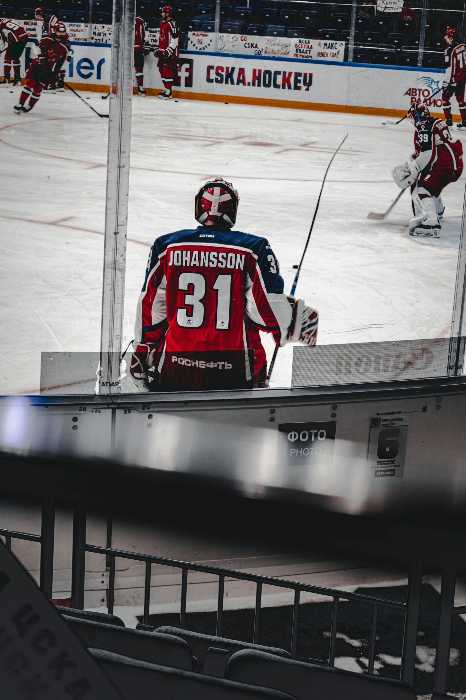 there is a man sitting on the bench watching hockey