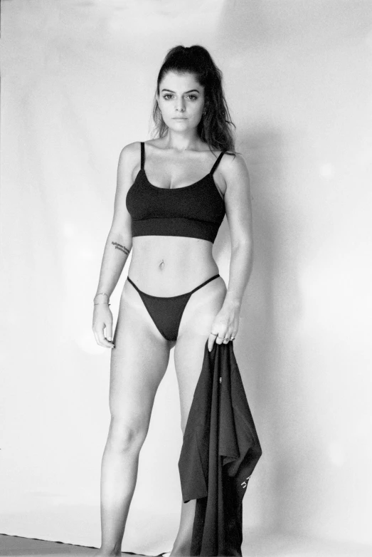 a woman in a bikini standing in front of a white background