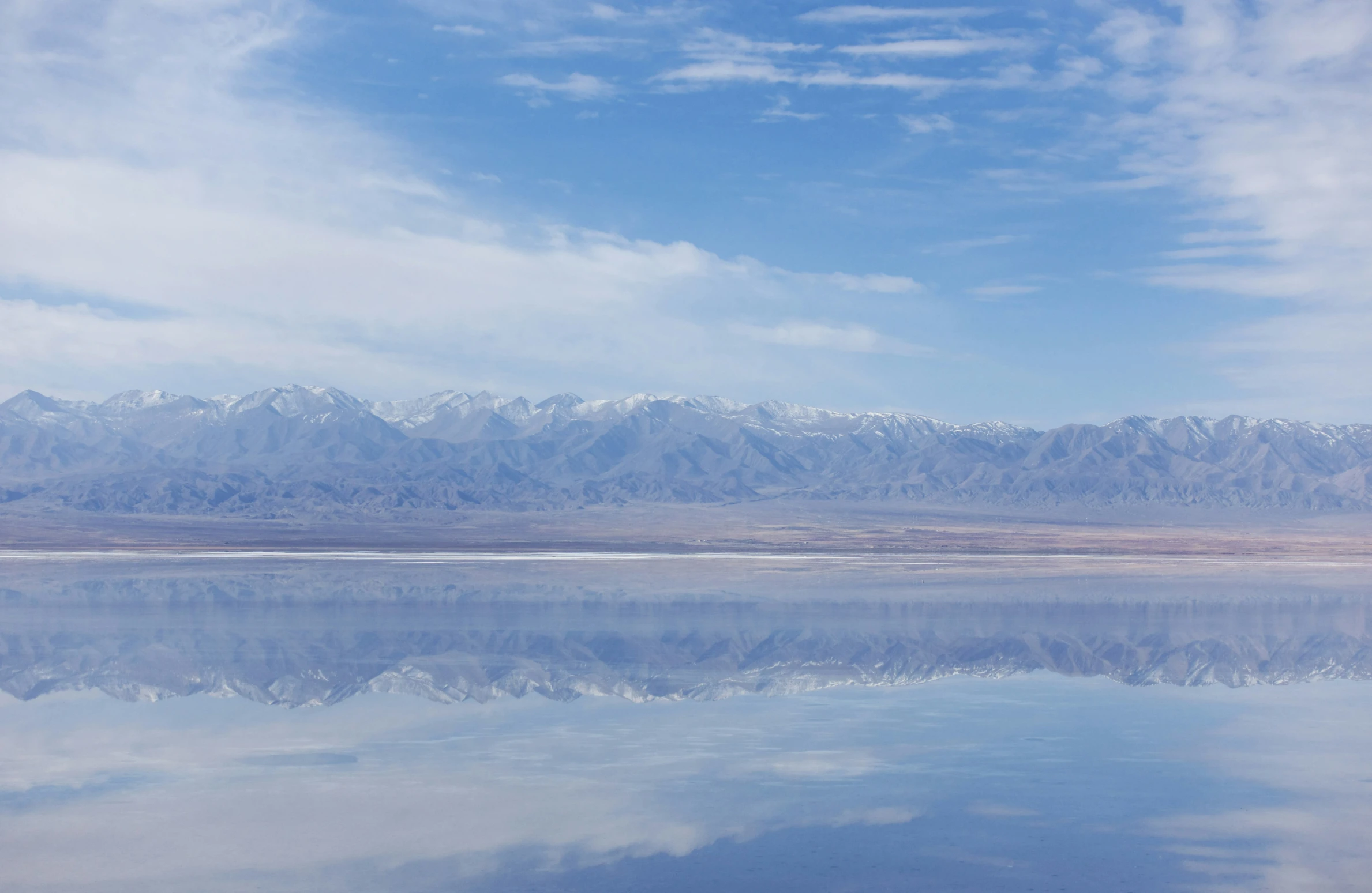 a beautiful lake surrounded by snow covered mountains