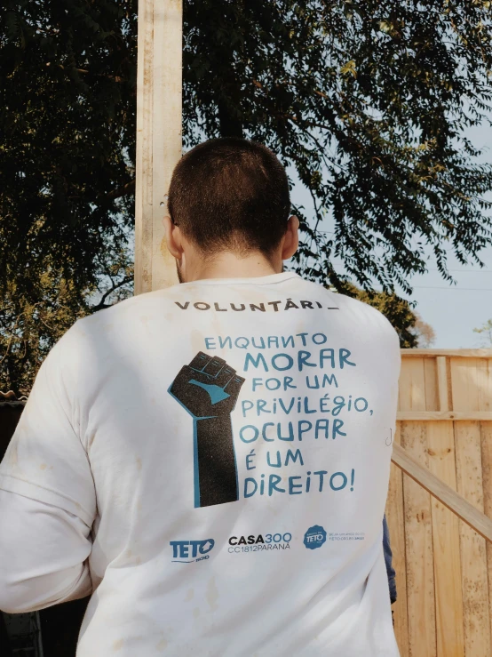 a man with a back tie on standing next to a tree