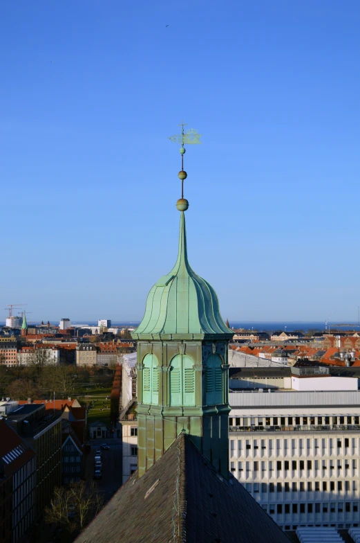 a tower with a weather vane on top overlooking the city