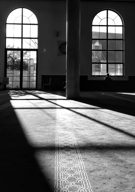 an empty room with two large arched windows