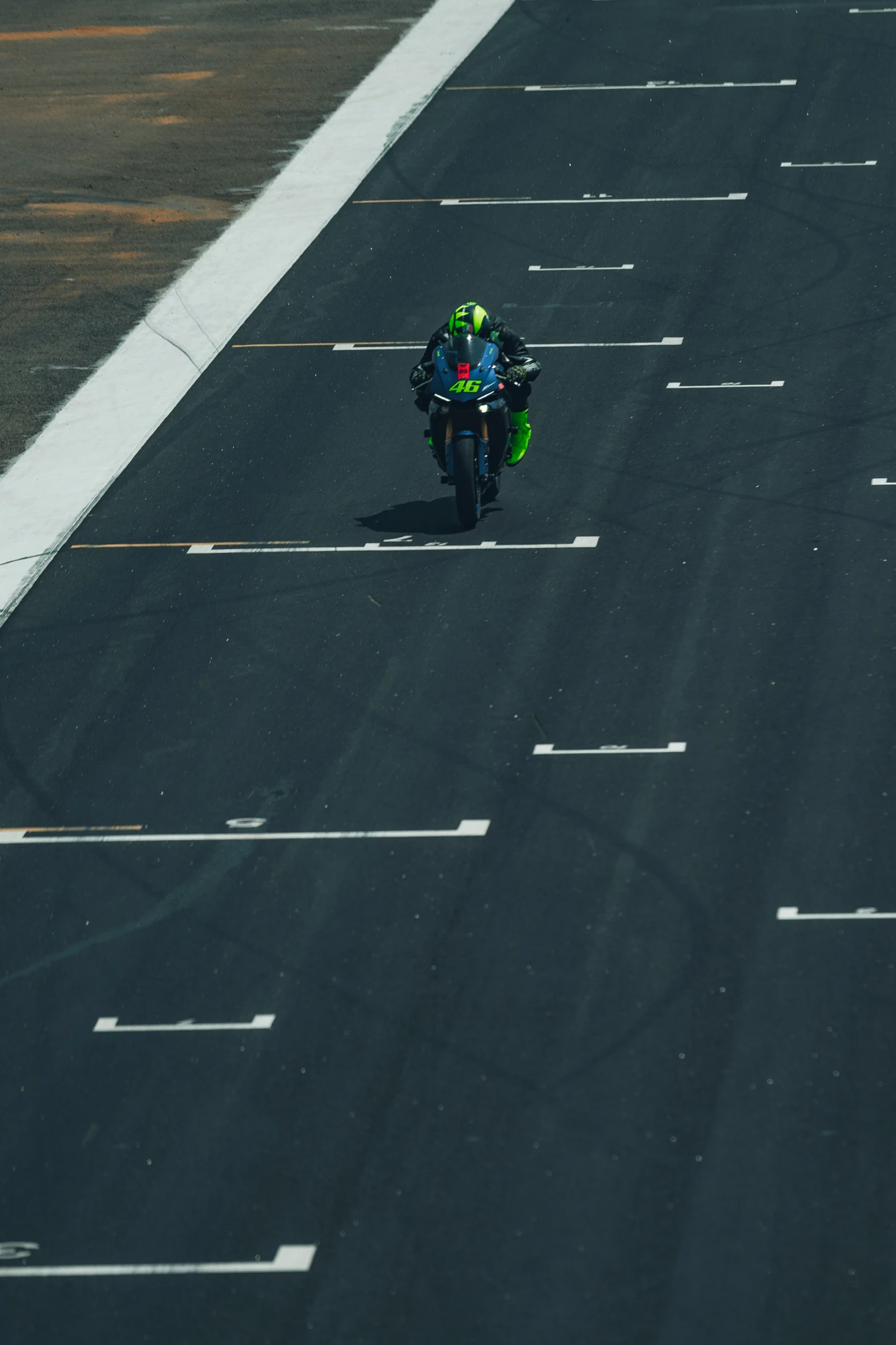 a person riding on the back of a motorcycle down a race track