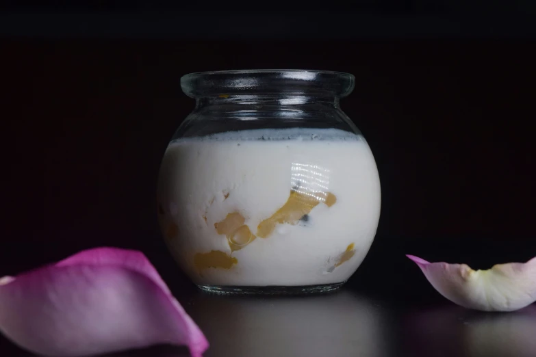 a glass vase with some milk inside on a table