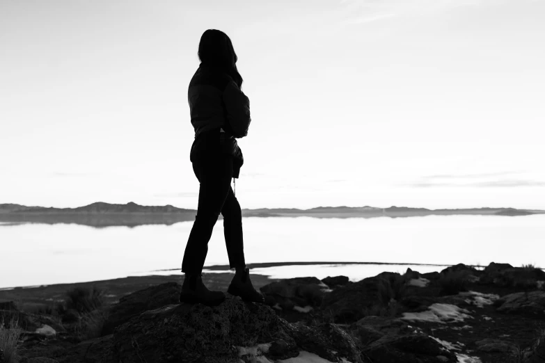 a person standing on top of a rock looking out at the water