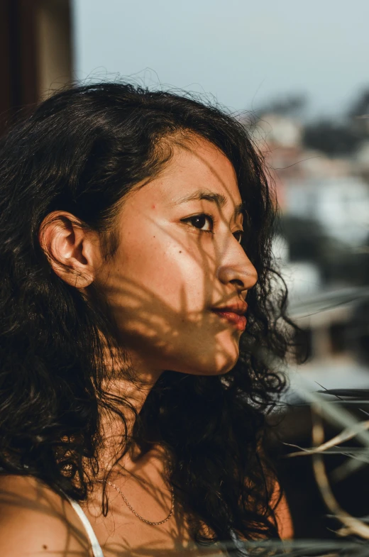 a woman with dark hair staring away from the camera