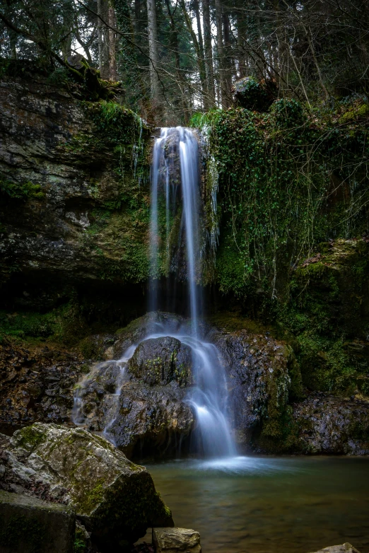 a waterfall that is surrounded by trees and water