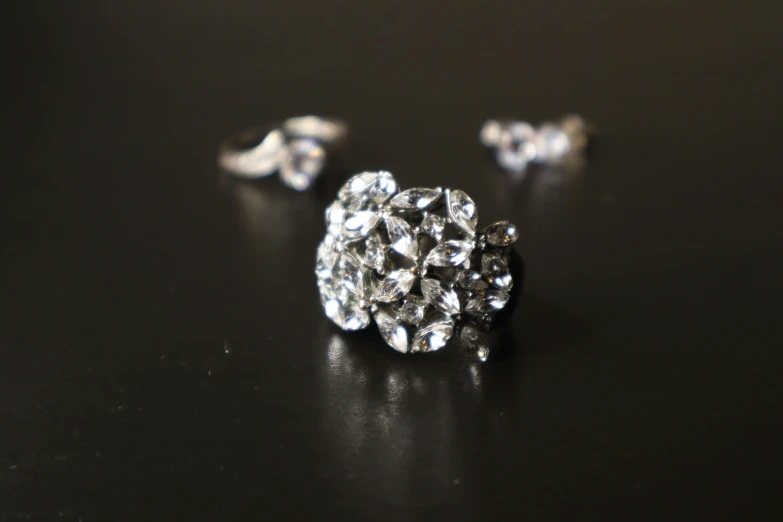 a close up of a diamond earring that is set on a table