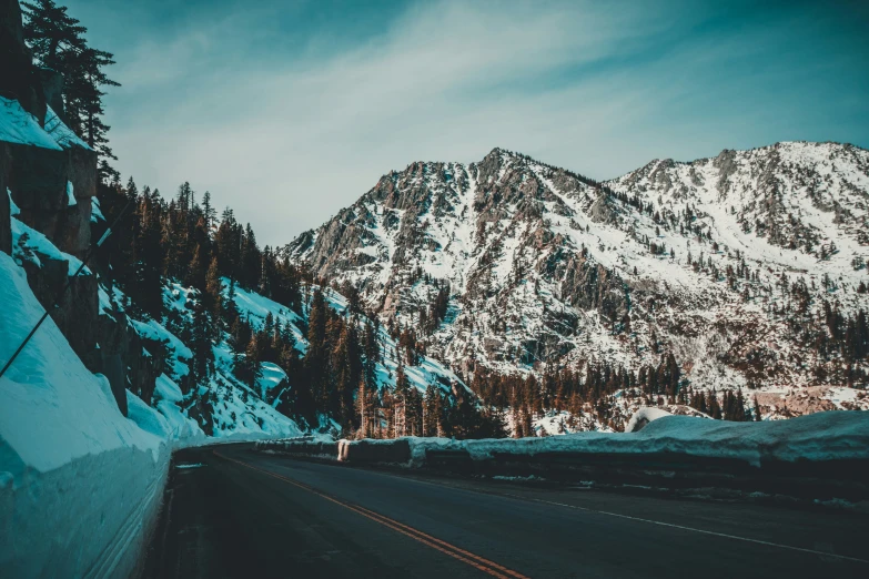 a road in the middle of snowy mountains