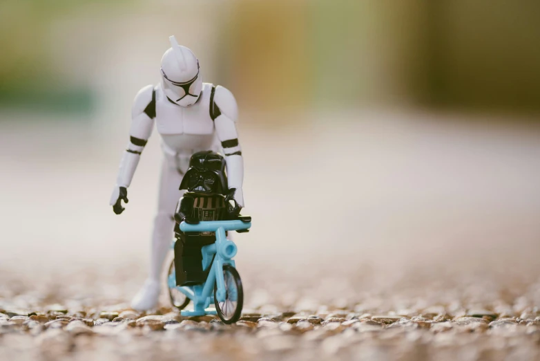 a figurine of a star wars character riding on a blue bike