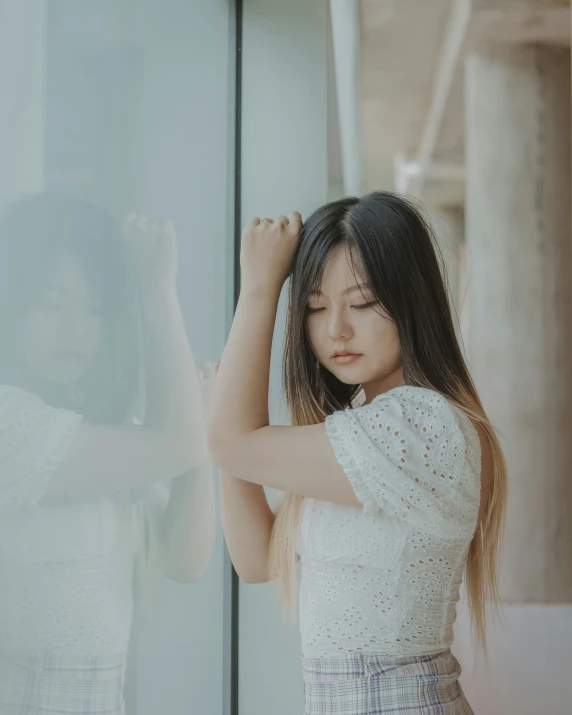 asian woman standing near glass in front of a large window