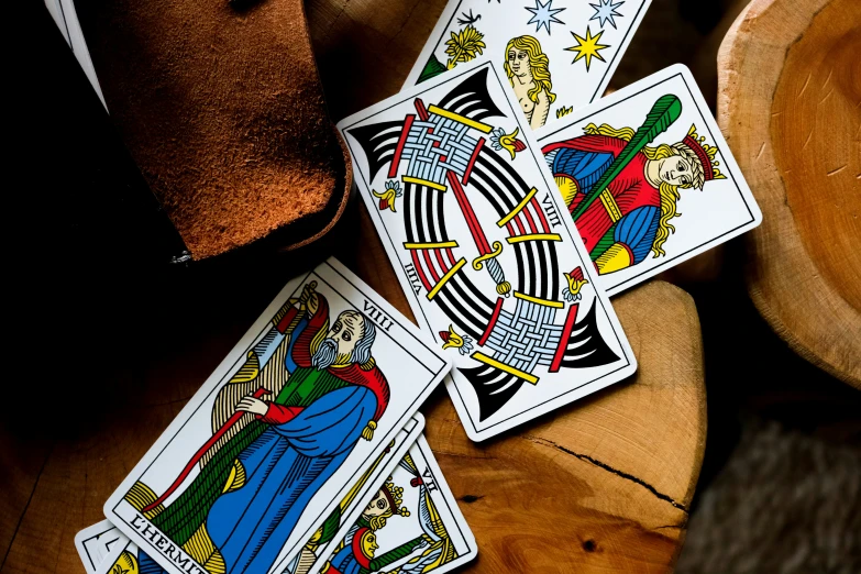 four tarot cards sitting on top of a wooden table