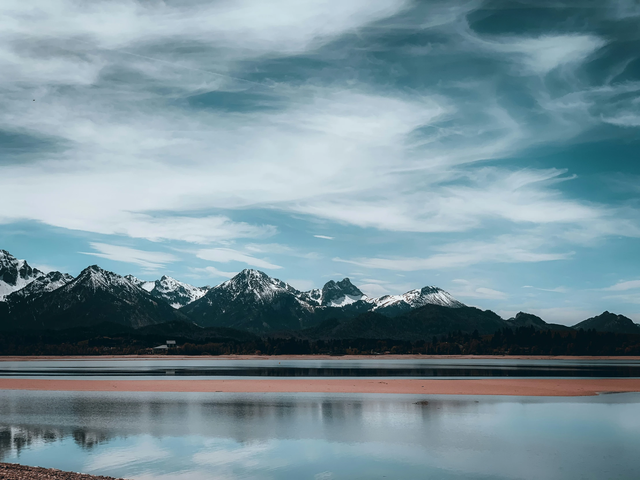 a lone boat is on a lake surrounded by mountains