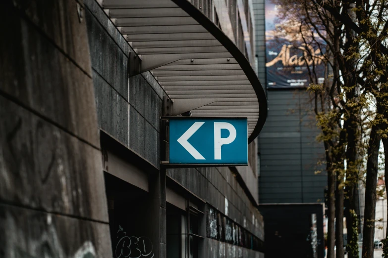 street sign on the side of a building indicating where the parking lot is