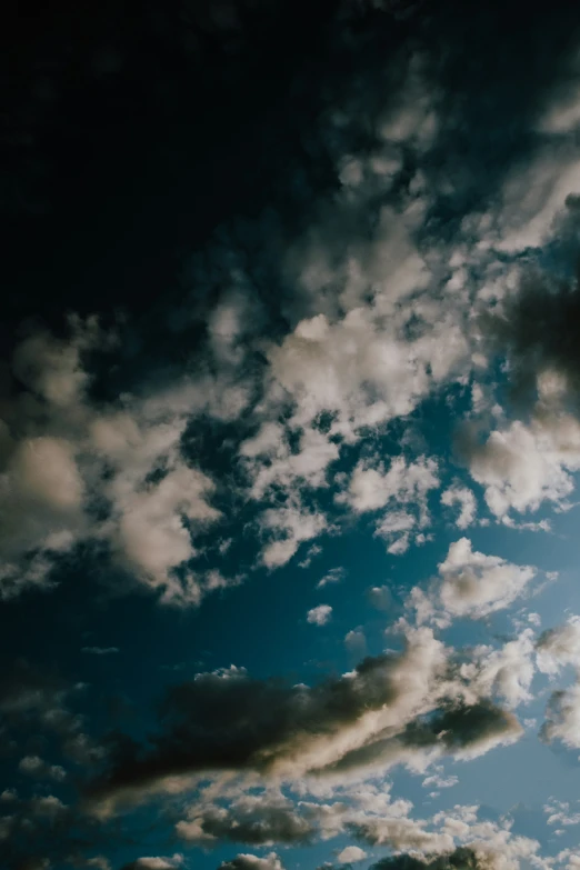 dark clouds over a grassy field under blue skies