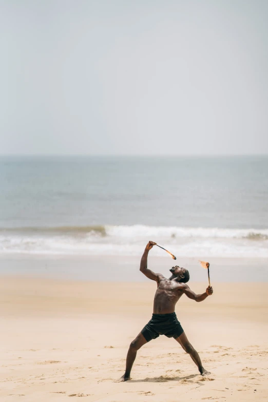 a man on the beach with a kite in his hands