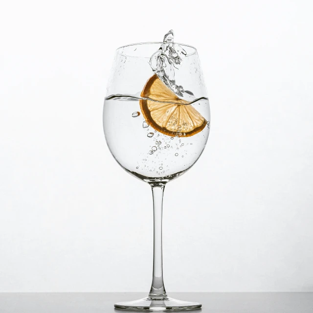 a glass of water with an orange floating on top