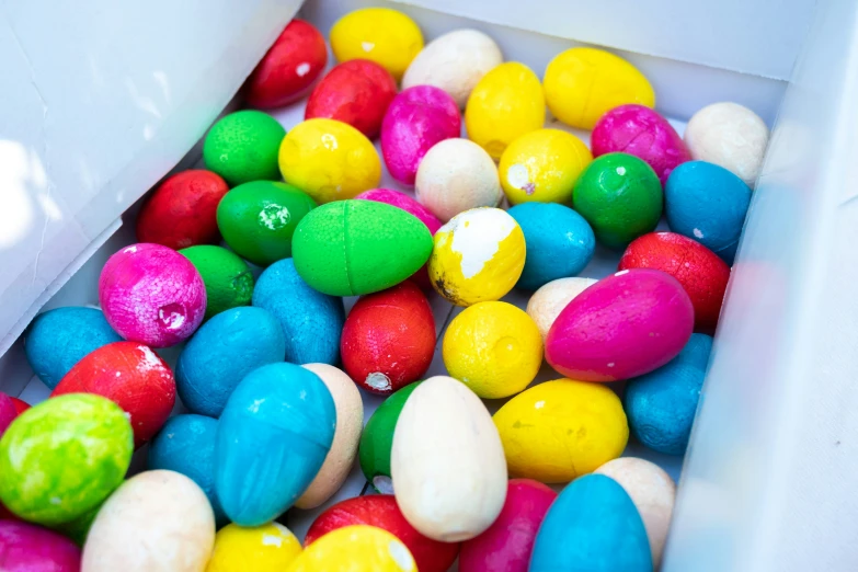 some fake eggs and candy in a plastic container