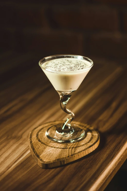 a small glass of drink sitting on a wood table