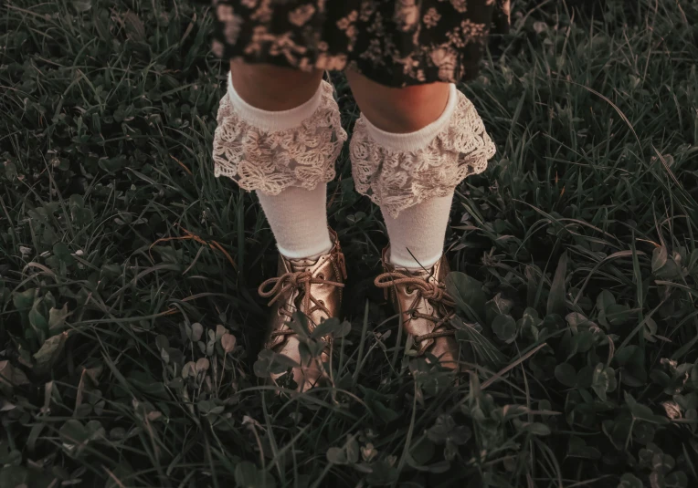 a woman wearing gold shoes in the grass