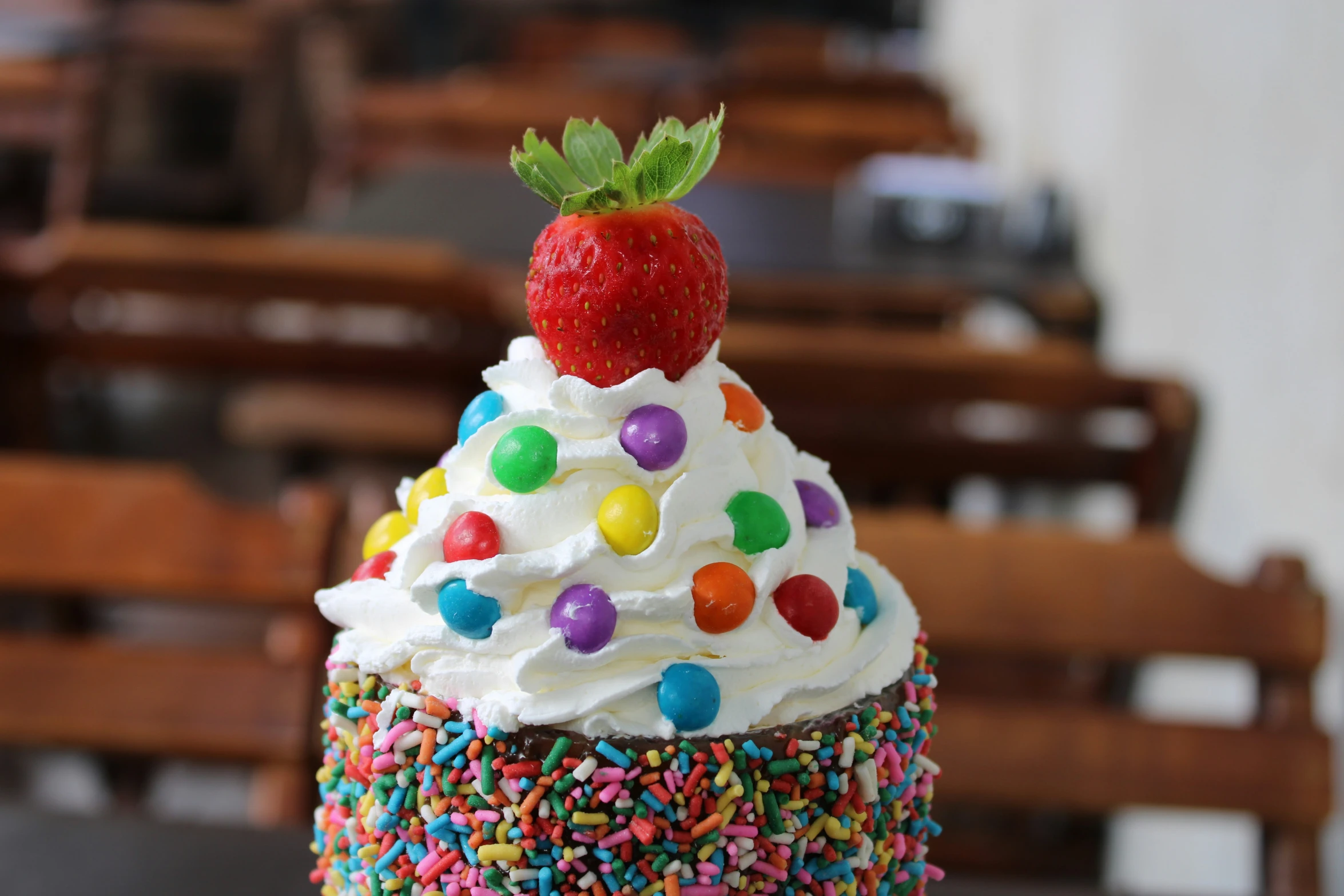 a cupcake is topped with frosting, sprinkles and a strawberry