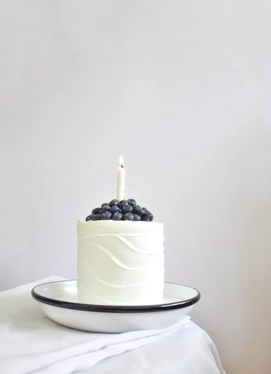 a cake with two candles and some berries