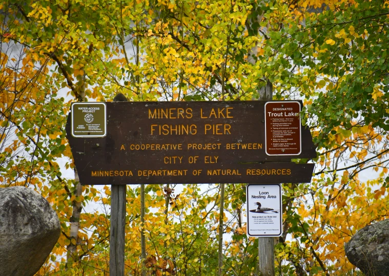 a sign on the side of a rock that says mines lake fishing pier