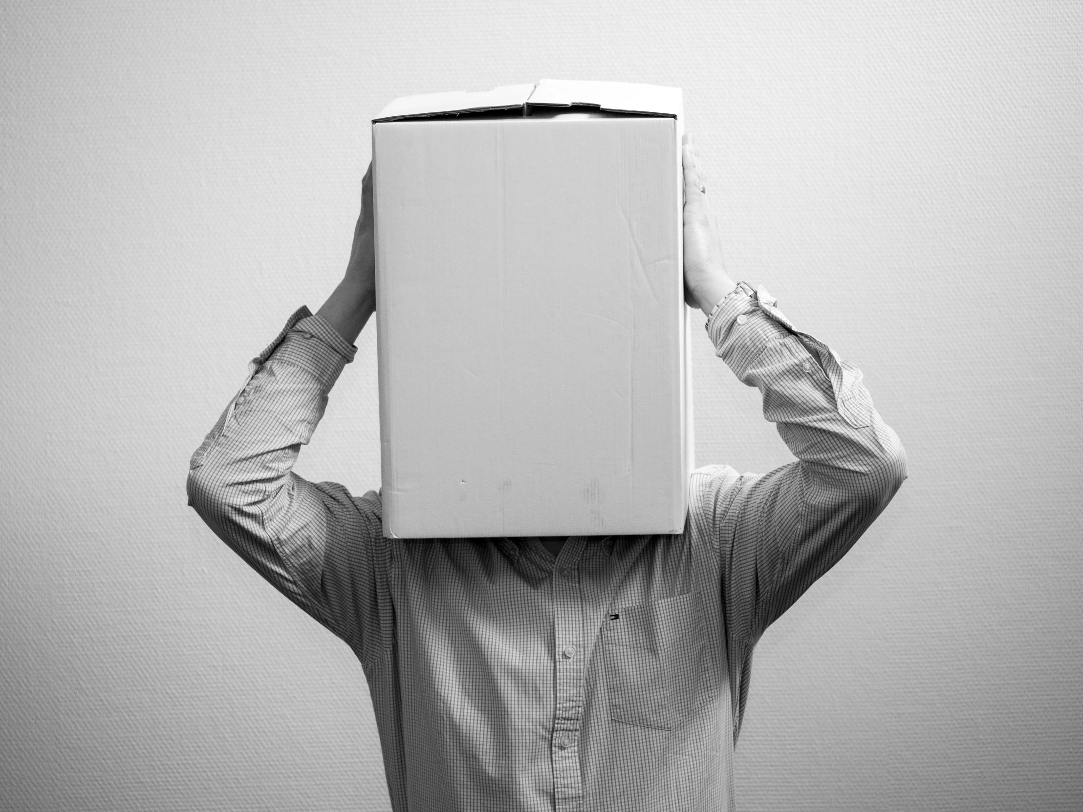 a woman covering her head with a box above her head