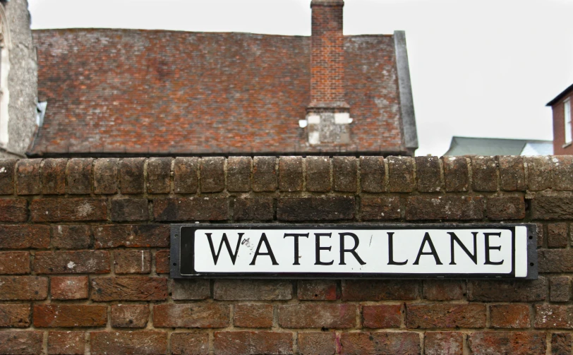 a street sign is attached to a brick wall