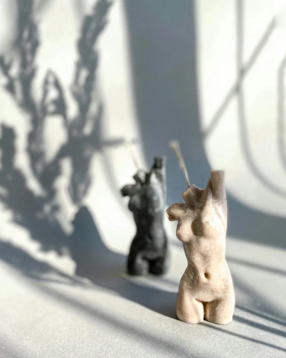 two figurines are shown with shadow on the wall