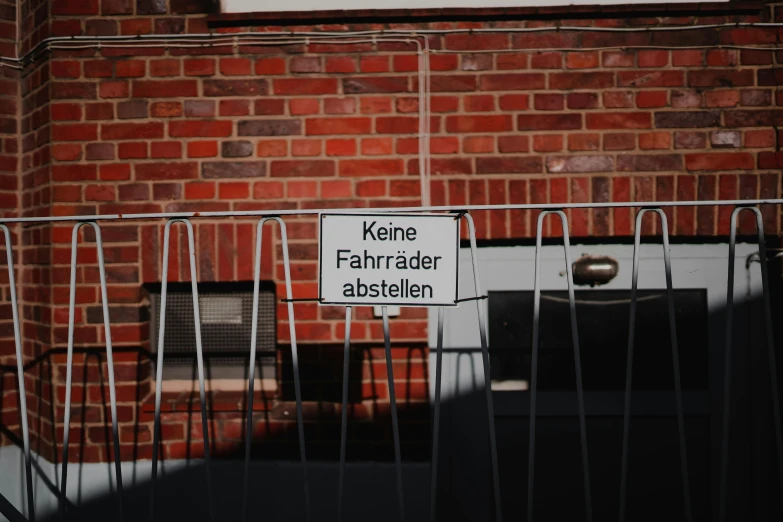 a sign is attached to the fence with wires