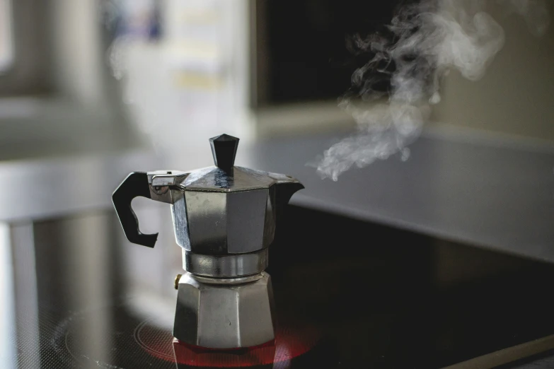 an espresso coffee maker that is on the stove