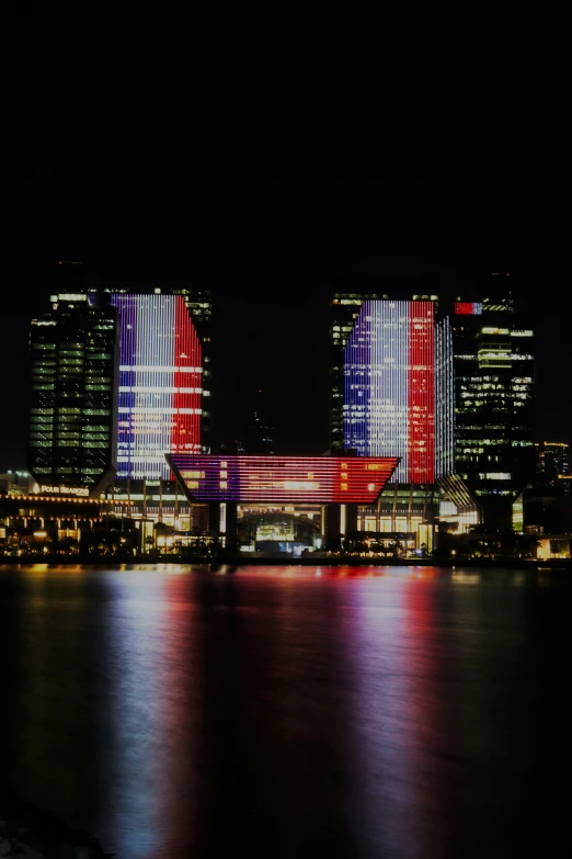 a large building in the city lit up with red, white and blue lights