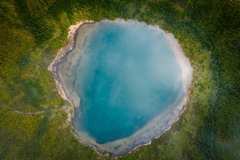 an aerial view of a large lake and some trees