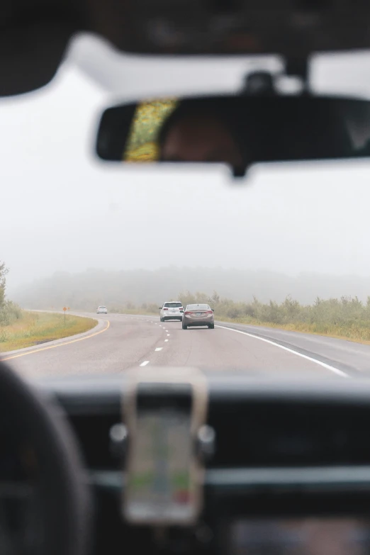 cars driving down the highway in a foggy weather