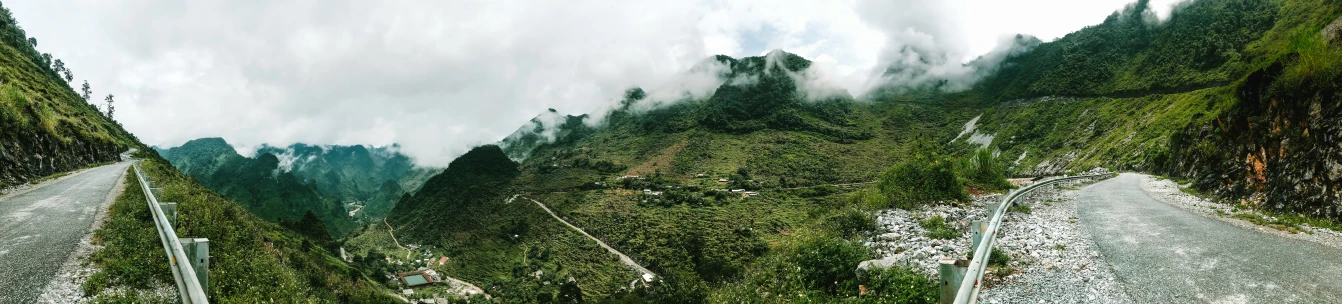 the mountain landscape has thick clouds and sp vegetation