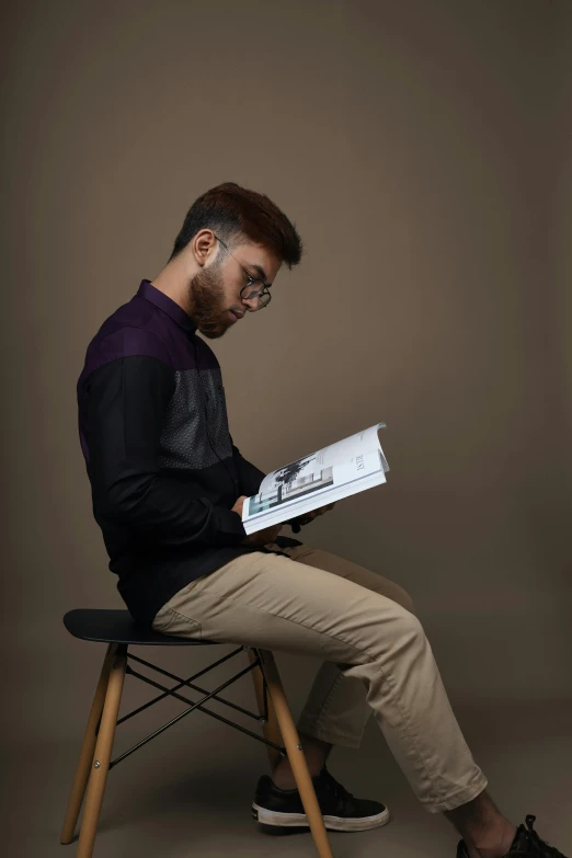 man sitting on chair with a large piece of paper