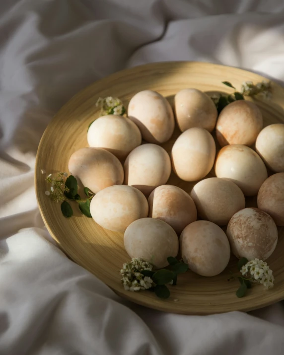 a plate filled with white eggs and green leaves