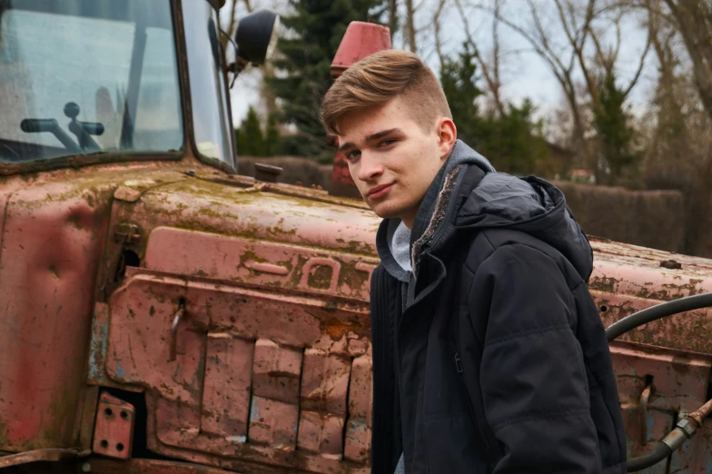 a man standing in front of a red tractor