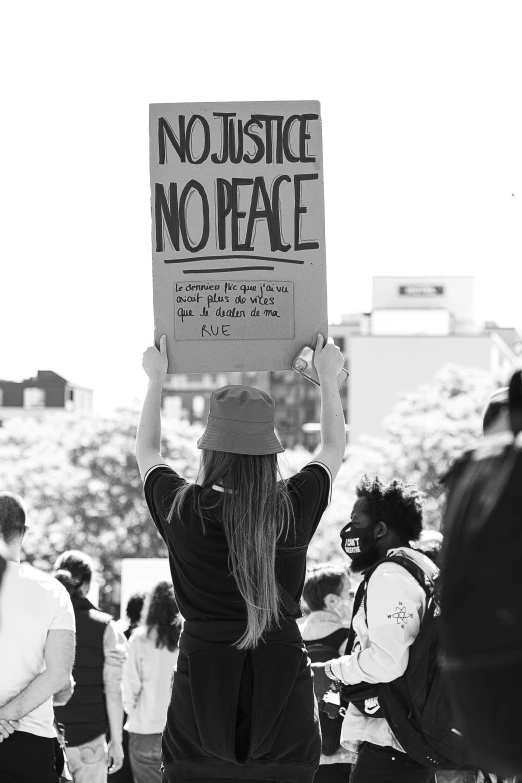 the person is protesting while holding a sign