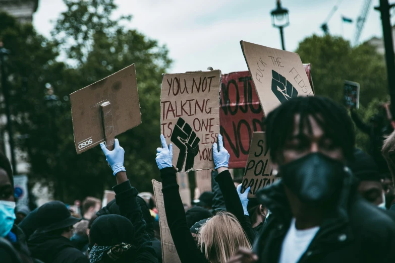 a group of people holding placares with writing on them