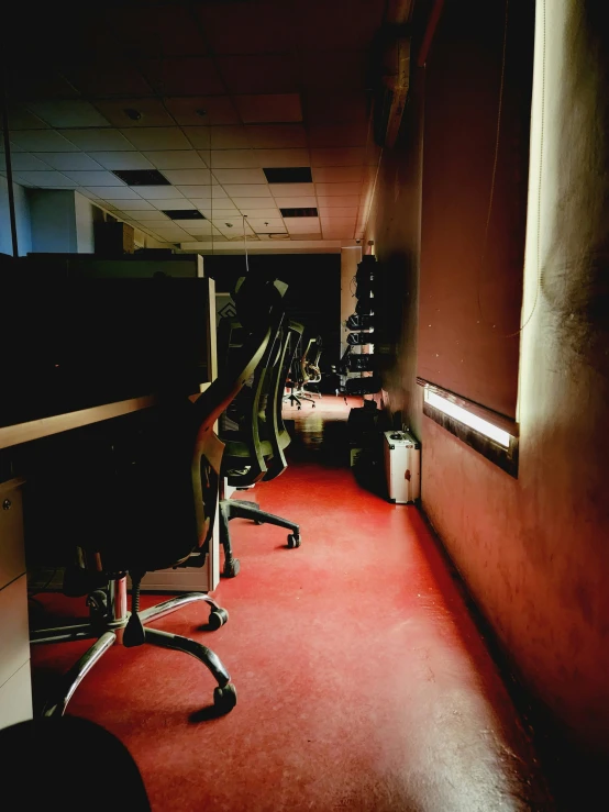 a desk chair and computer screen in an empty room