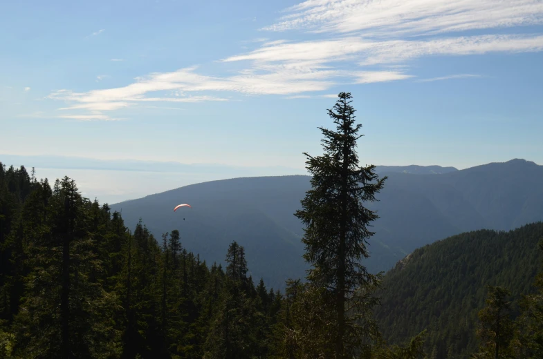 the view is looking down at mountains and trees