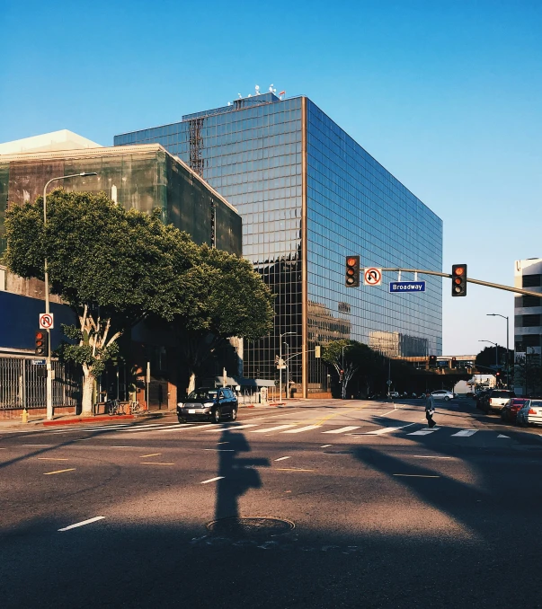 cars are driving on the street in front of a high rise building