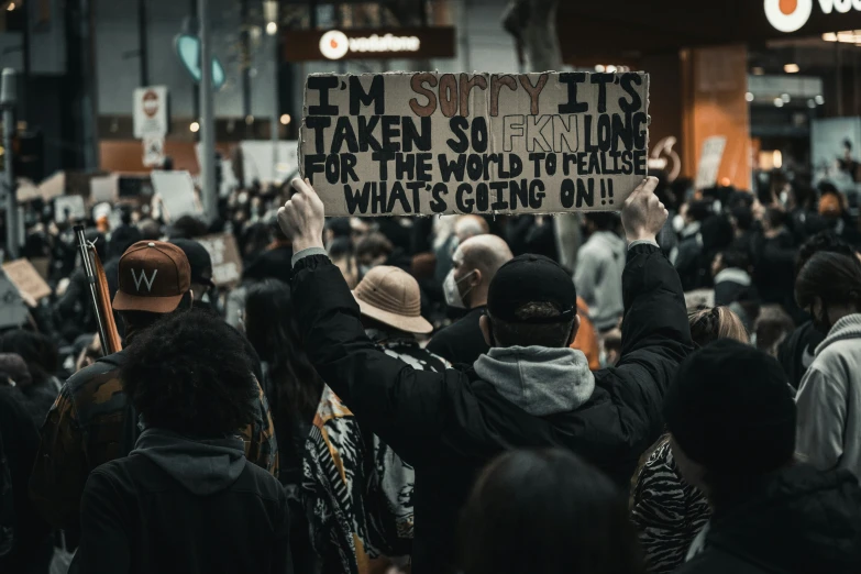 a bunch of people standing together holding signs