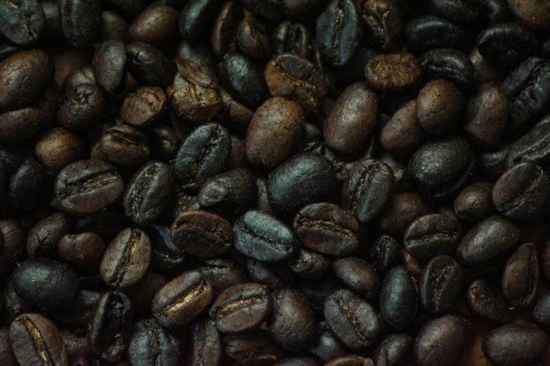 a pile of coffee beans with a bunch of them being held together