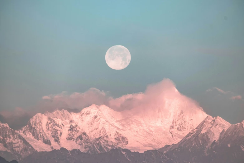a beautiful moon rises above a mountain range