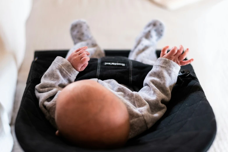 a baby laying on top of an object in the bed